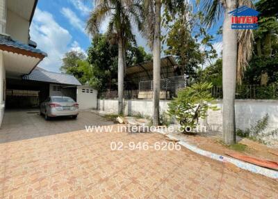 Driveway and backyard view with car and trees