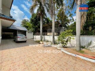 Driveway and backyard view with car and trees