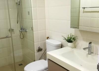 Modern bathroom with glass shower, toilet, sink, and mirror