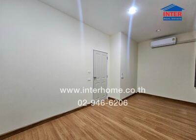 Spacious bedroom with wooden floor and air conditioning