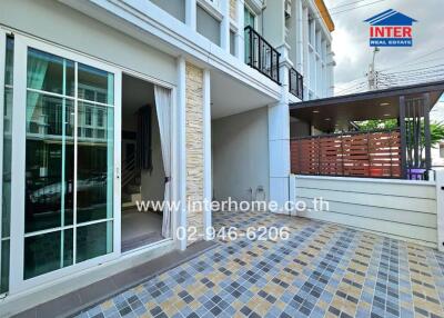 Exterior view of a modern townhouse with patio and balcony