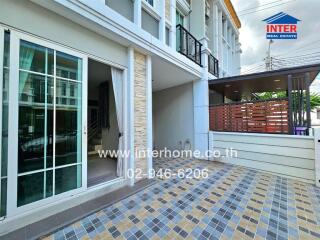 Exterior view of a modern townhouse with patio and balcony