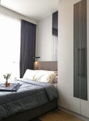 Modern bedroom with large window, bed, and wardrobe