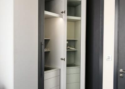 Modern wardrobe with open doors in a bedroom showing shelves and drawers