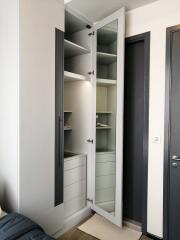 Modern wardrobe with open doors in a bedroom showing shelves and drawers