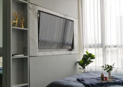 Bedroom with wall-mounted TV, air conditioner, and large window