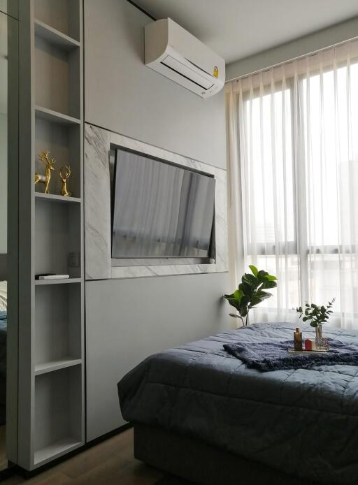 Bedroom with wall-mounted TV, air conditioner, and large window