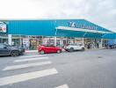 Exterior view of a supermarket with several parked cars