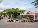 Exterior view of commercial area with buildings, parking, and tree