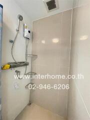 Bathroom with shower, water heater, and shelves