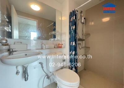 Modern bathroom with double sinks, shower area, and toilet