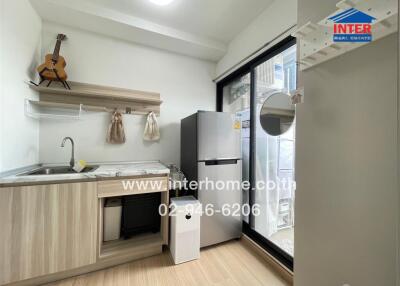 Modern kitchen with wooden cabinetry and stainless steel refrigerator