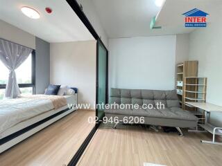 Bedroom with bed, glass partition, sofa, and shelving unit