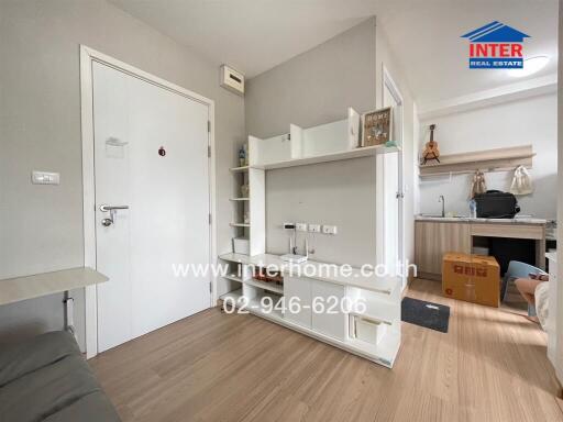 Interior of a modern living area with a small kitchen and storage shelves