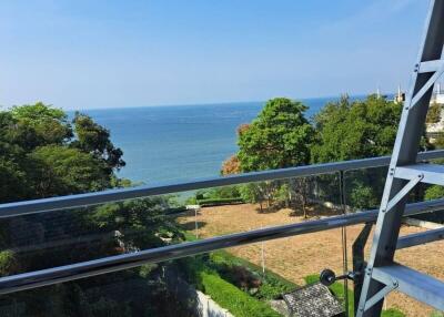 Scenic view of the sea from a balcony with glass railing and a steel structure