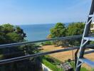 Scenic view of the sea from a balcony with glass railing and a steel structure