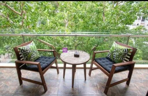 Cozy balcony with chairs, table, and greenery view