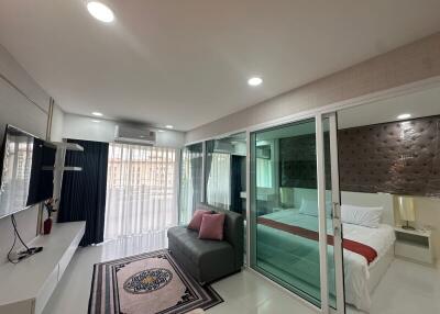 Modern living area with glass wall to bedroom