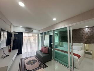 Modern living area with glass wall to bedroom