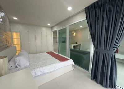Spacious modern bedroom with large window and sliding doors