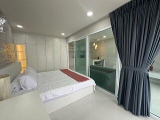 Spacious modern bedroom with large window and sliding doors