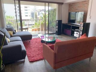 Cozy living room with large windows, modern furniture, and balcony access