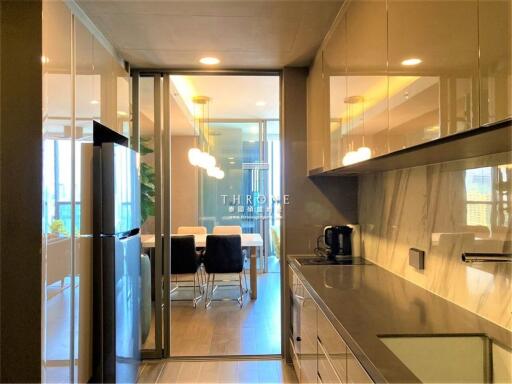 Modern kitchen with appliances and dining area in the background