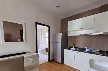 Modern kitchen with white cabinets, stainless steel appliances, and wooden flooring