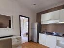 Modern kitchen with white cabinets, stainless steel appliances, and wooden flooring