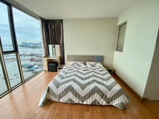 A spacious bedroom with a large bed and a view of the sea.