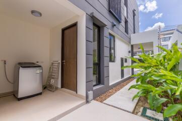 Modern house with side area, washing machine, and garden