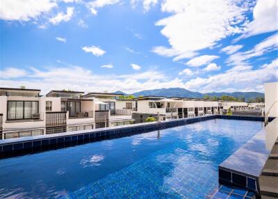 Rooftop pool with view of modern townhouses and mountains