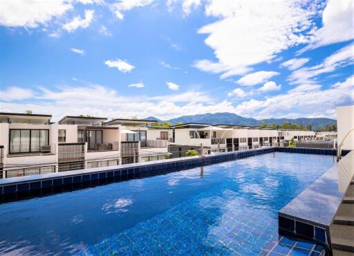 Rooftop pool with view of modern townhouses and mountains