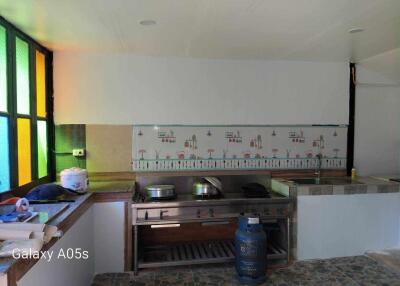 Spacious kitchen area with vibrant stained-glass windows and a large stove