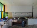 Spacious kitchen area with vibrant stained-glass windows and a large stove