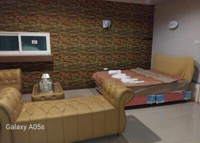 Bedroom with a sofa, a double bed, and a decorated wall