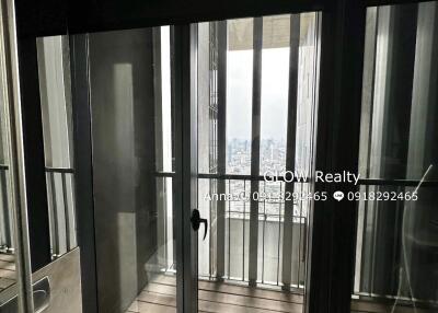 Modern bathroom with a glass door leading to a balcony and a view of a city