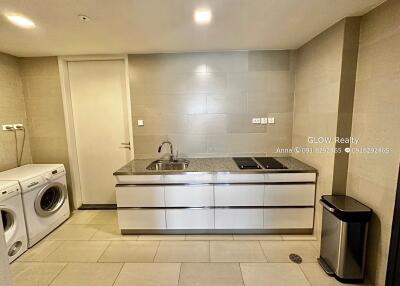 Modern laundry room with washing machine and dryer, large countertop and storage cabinets.