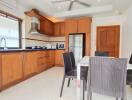 Modern kitchen and dining area with wooden cabinets and appliances