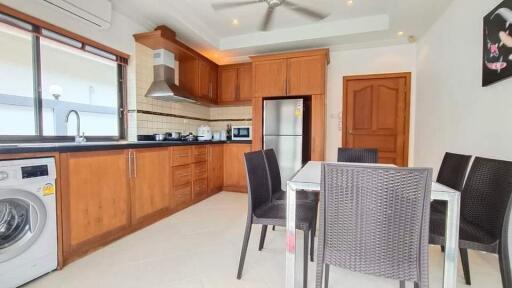 Modern kitchen and dining area with wooden cabinets and appliances