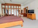 Spacious bedroom with wooden furniture and large mirror wardrobe