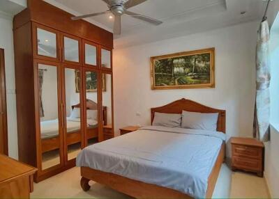 Bedroom with wooden furnishings and a large mirrored wardrobe