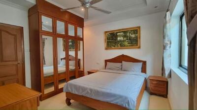 Bedroom with wooden furnishings and a large mirrored wardrobe