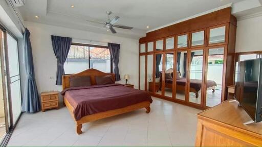 Spacious bedroom with large mirror wardrobe and access to natural light