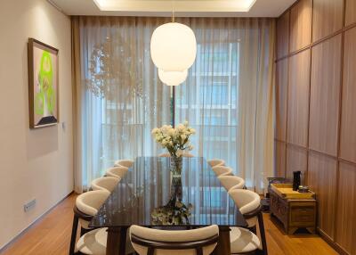 Modern dining room with a large glass table and pendant lighting