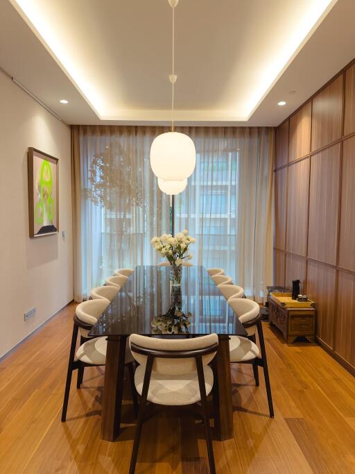 Modern dining room with a large glass table and pendant lighting