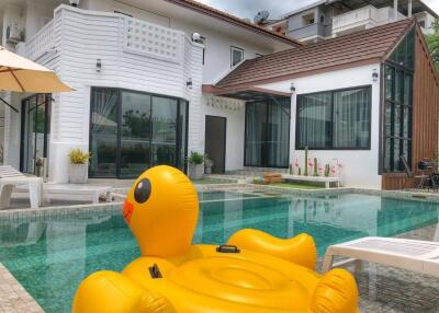 Spacious backyard with pool and inflatable duck float