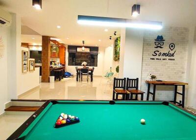 Modern open-plan living area with a pool table and dining space