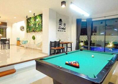 Modern living area with pool table and dining space