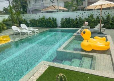 Swimming pool area with inflatable duck and lounge chairs